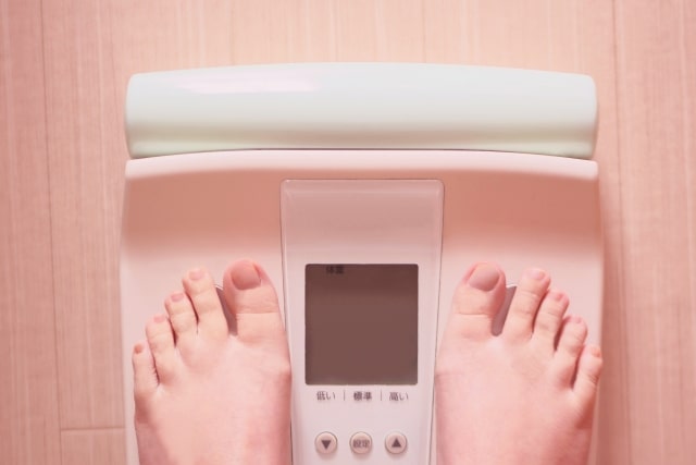 糖質制限中に体重計に乗る女性