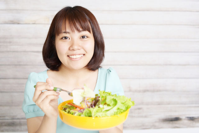 サラダを食べる女性